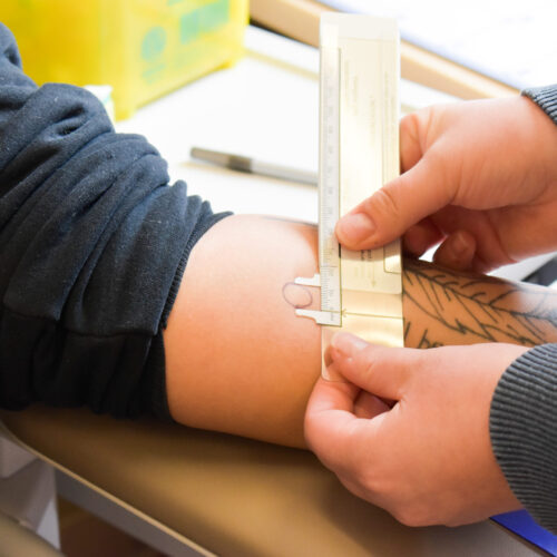 a person measuring the tattoo design on other person's hand